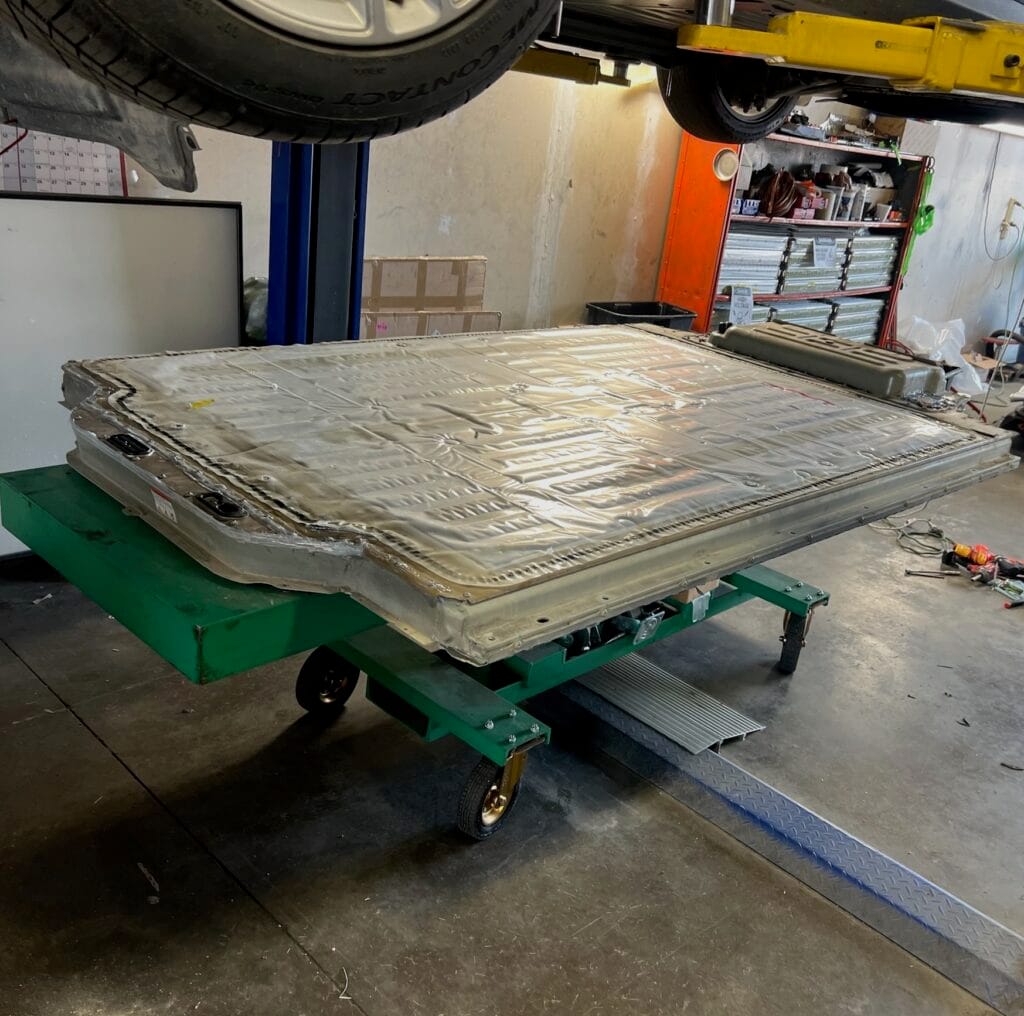 High-voltage battery pack replacement on shop cart at AT Automotive Sacramento